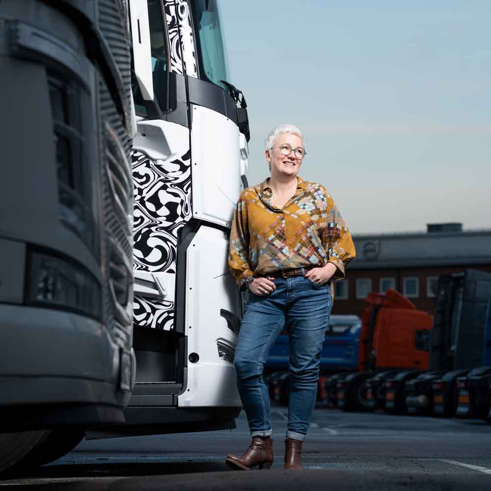 Carina Byström leans against the cab exterior of the Volvo FM